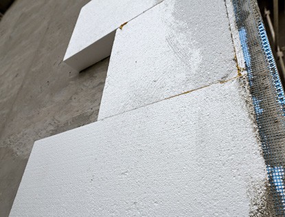 Detalle en primer plano de la pared de una casa con aislante de espuma rígida de poliestireno