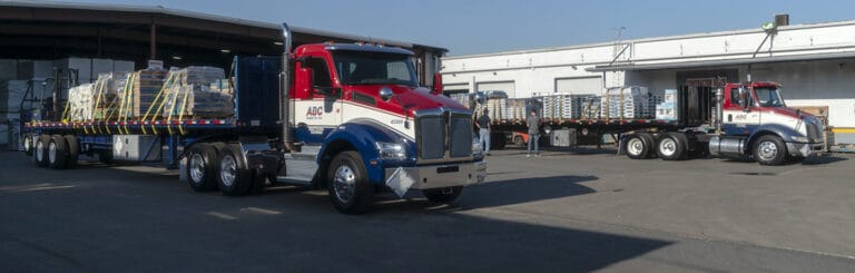 Two ABC Supply Semi Tractor Trucks In The Supply Yard