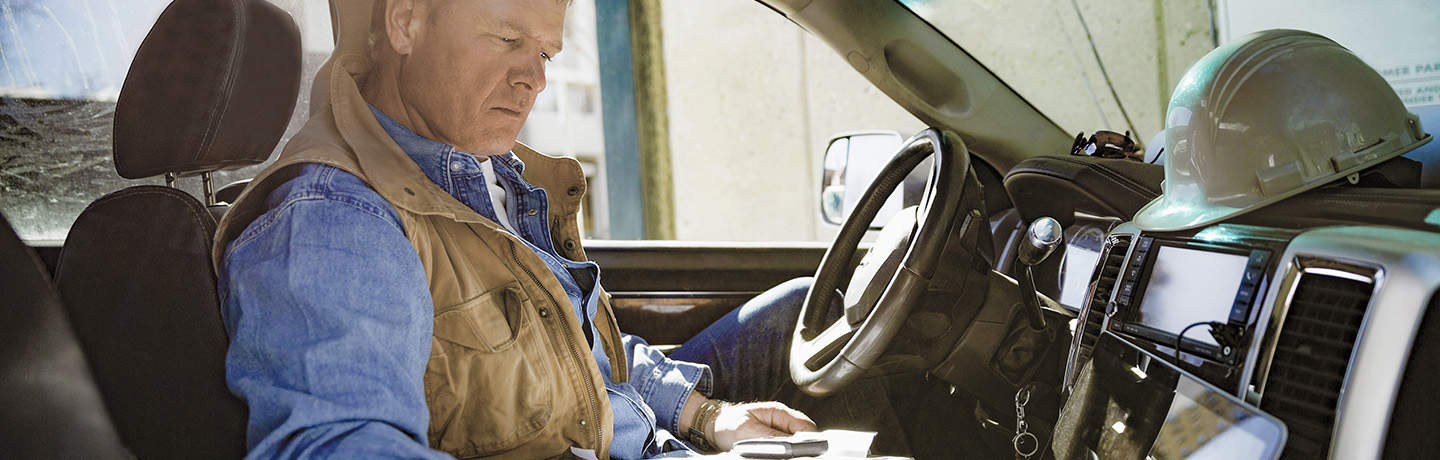 Foreman Using Laptop Computer In His Truck