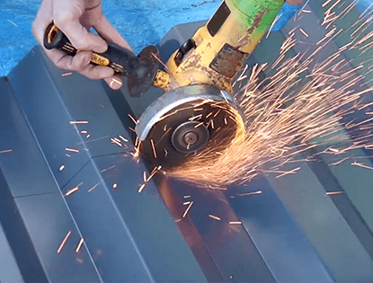 Manos cortando revestimiento exterior de acero con una herramienta eléctrica