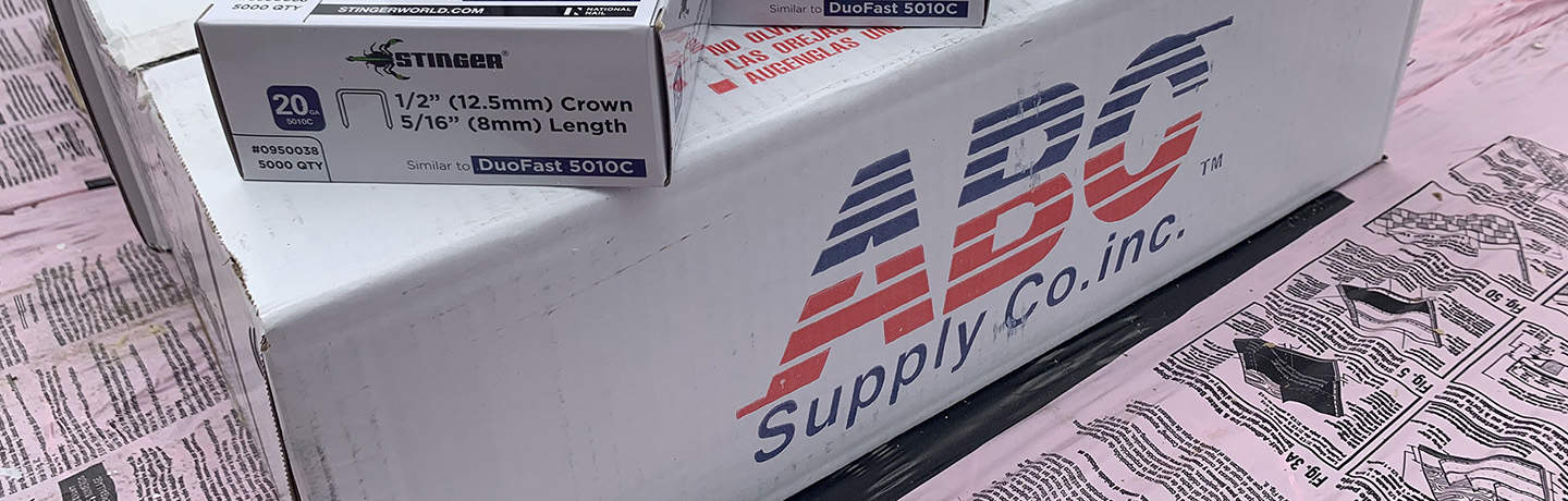 Una caja de ABC Supply con grapas y tejas