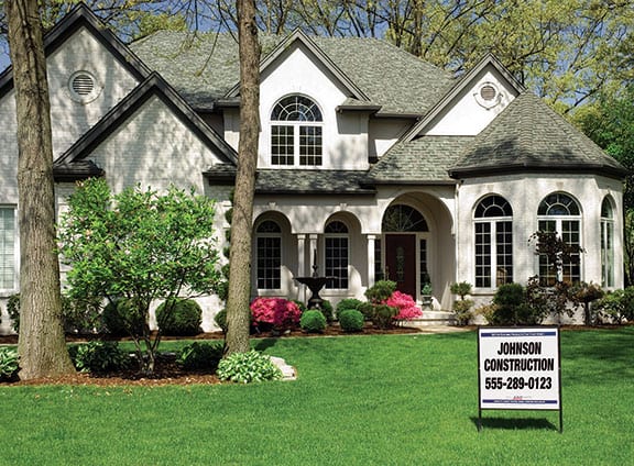 Home Exterior with Construction Company Yard Sign in Lawn